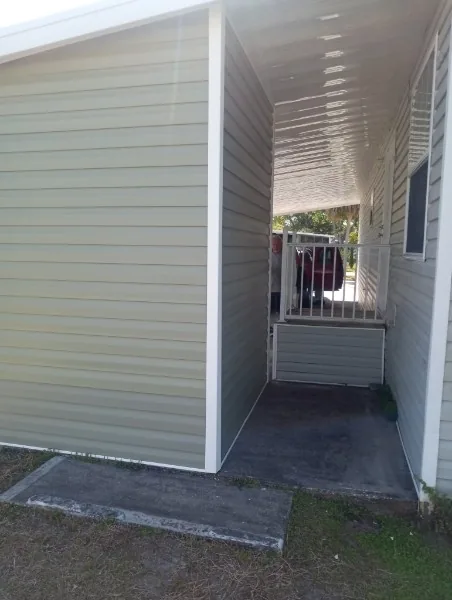 Covered side walkway with light-colored siding and a roof