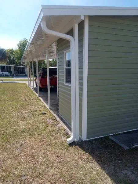 Covered carport exterior with roof, columns, and guttering