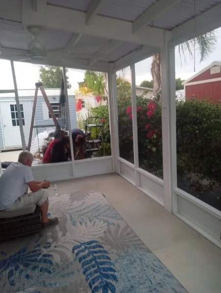 White screened room interior during work, with people and a ladder visible